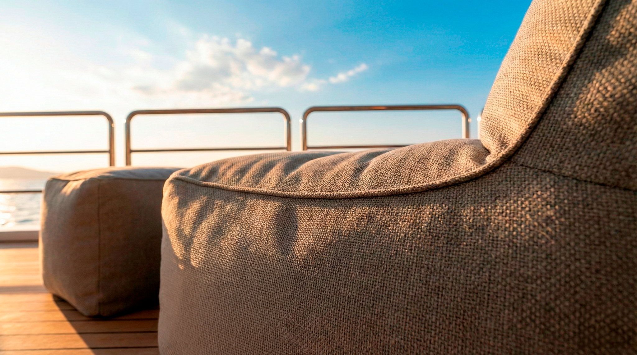 Brown textured outdoor chair on a wooden deck with a clear blue sky.